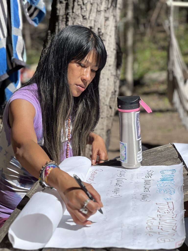 A woman taking notes in the Courses & Training working group at the Convergence for Intentional Communities