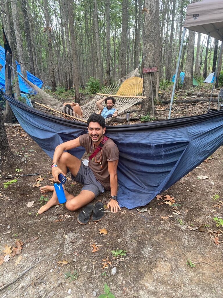 Rodrigo & Cristo from the FIC sitting by a hammock smiling and laughing